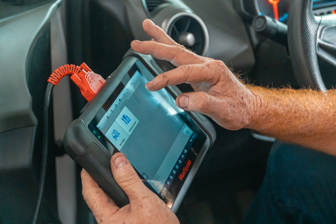 Technician using a handheld automotive diagnostic scan tool