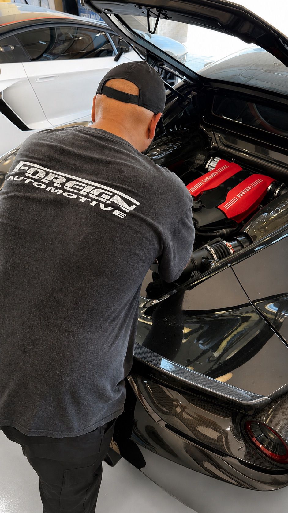 Foreign Automotive technician working at a Ferrari engine bay