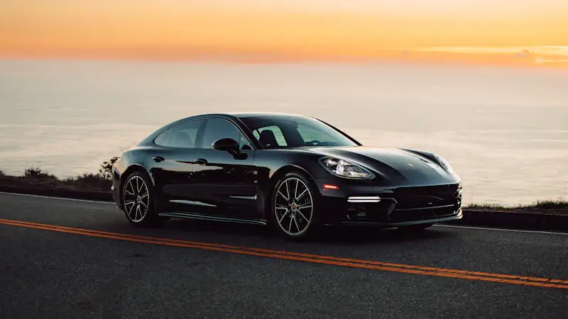 Porsche Panamera on a coastal road at sunset
